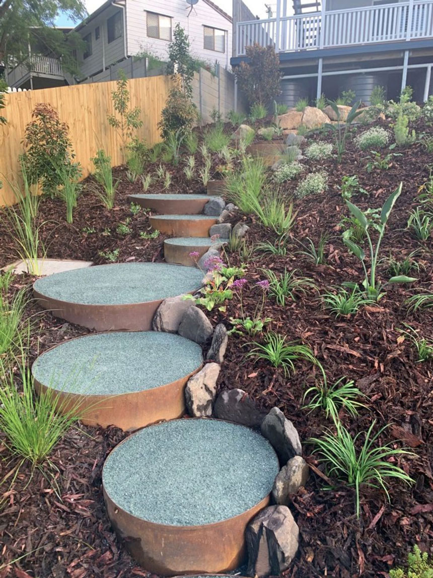Weathering steel garden edging formed into stepped rings, a sculptural technique that adds dimension to flat gardens