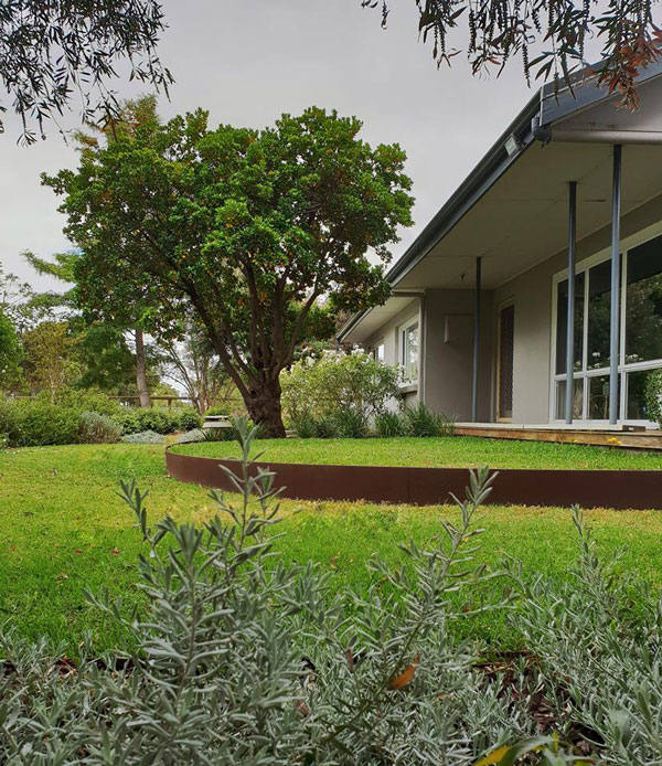 Elevated lawn with steel edging creating a tiered effect, a striking design for sloped gardens