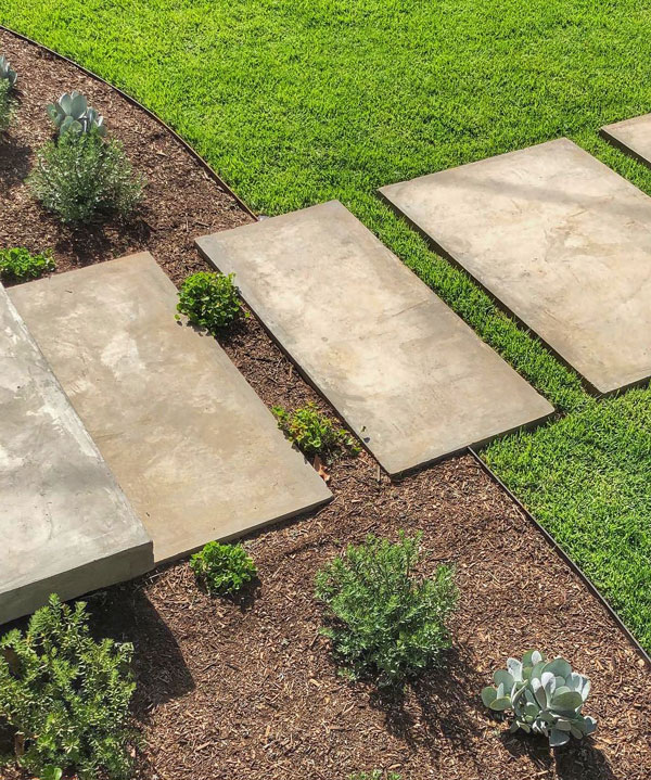 Stone steppers set into a lawn to create a garden path, a creative edging and design solution